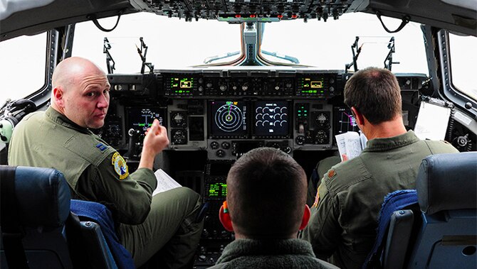 Capt. Brandon Reynolds, a pilot with the 300th Airlift Squadron at Joint Base Charleston, S.C., receives information from an aerial port member while on a training mission at Ramstein Air Base, Germany, Jan. 23, 2016.