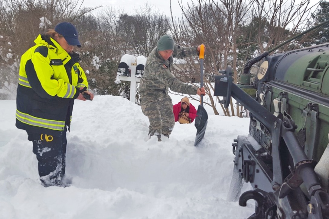 A soldier helps clear a path while assisting the Waynesboro First Aid Crew with a rescue call near Waynesboro, Va., Jan. 23, 2016. The soldier is with the Virginia National Guard’s Company D, 1st Battalion, 116th Infantry Regiment, 116th Infantry Brigade Combat Team. The first aid crew members were unable to reach the location of the call with their ambulance, so soldiers drove them to the residence, cleared a path and transported the patient to the ambulance for evacuation. Virginia National Guard photo by Army Sgt. Chris Martrano