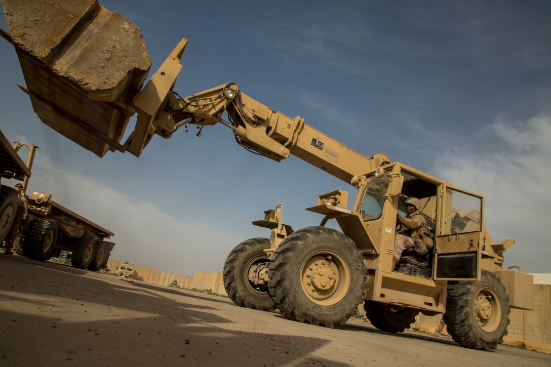 U.S. Marine Corps Cpl. Marquis Jeffers, heavy equipment operator with Special Purpose Marine Air-Ground Task Force-Crisis Response-Central Command, transports Alaskan barriers at Al Taqaddum Air Base, Iraq, Jan. 8, 2016. The 12-ton barriers are placed around structures to reinforce them and provide protection from shrapnel. Advise and assist sites, like Al Taqqadum Air Base, are an integral part of Combined Joint Task Force – Operation Inherent Resolve’s multinational effort to increase the military capacity of Iraqi Security Force personnel to defeat the Islamic State of Iraq and the Levant. (U.S. Marine Corps photo by Cpl. Akeel Austin/Released)