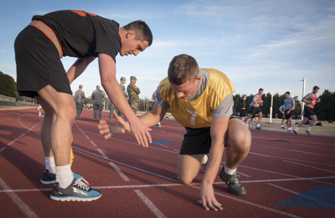 Army ROTC cadets Alex Berg, and Joe Hilbert help each other recover after completing the two-mile run during an Army Physical Fitness Test at Clemson University, S.C., Jan. 14, 2016. U.S. Army photo by Staff Sgt. Ken Scar