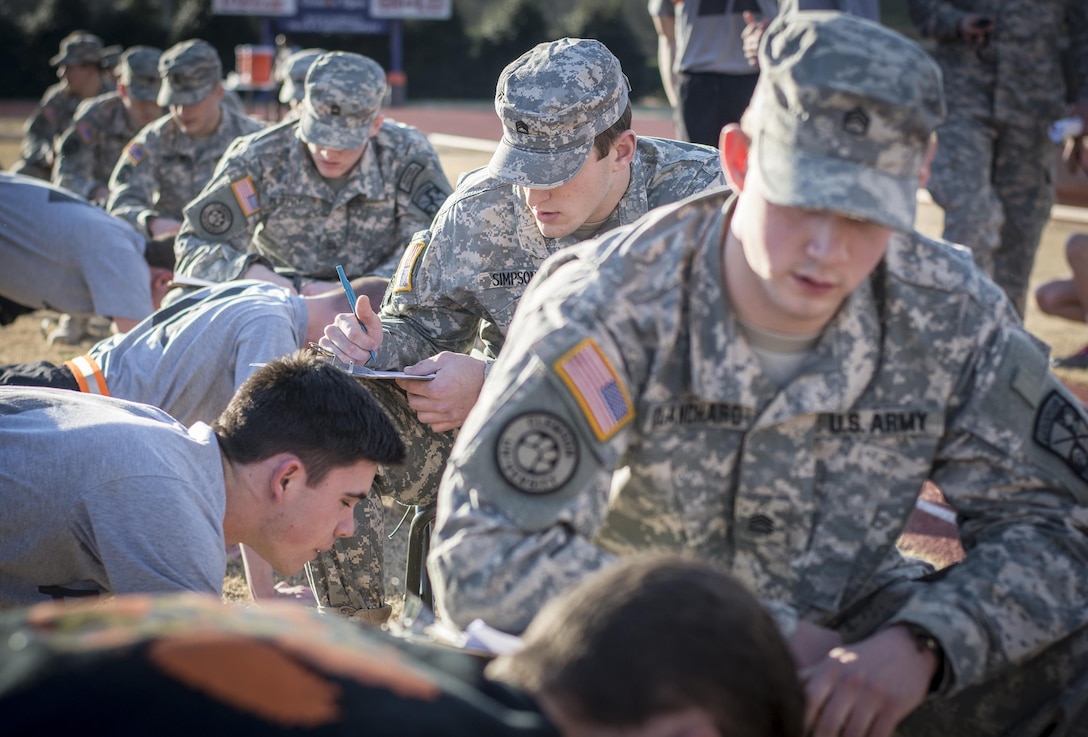 Army ROTC cadets in uniform count and grade pushups for freshman and sophomore cadets during an Army Physical Fitness Test at Clemson University, S.C., Jan. 14, 2016. U.S. Army photo by Staff Sgt. Ken Scar  