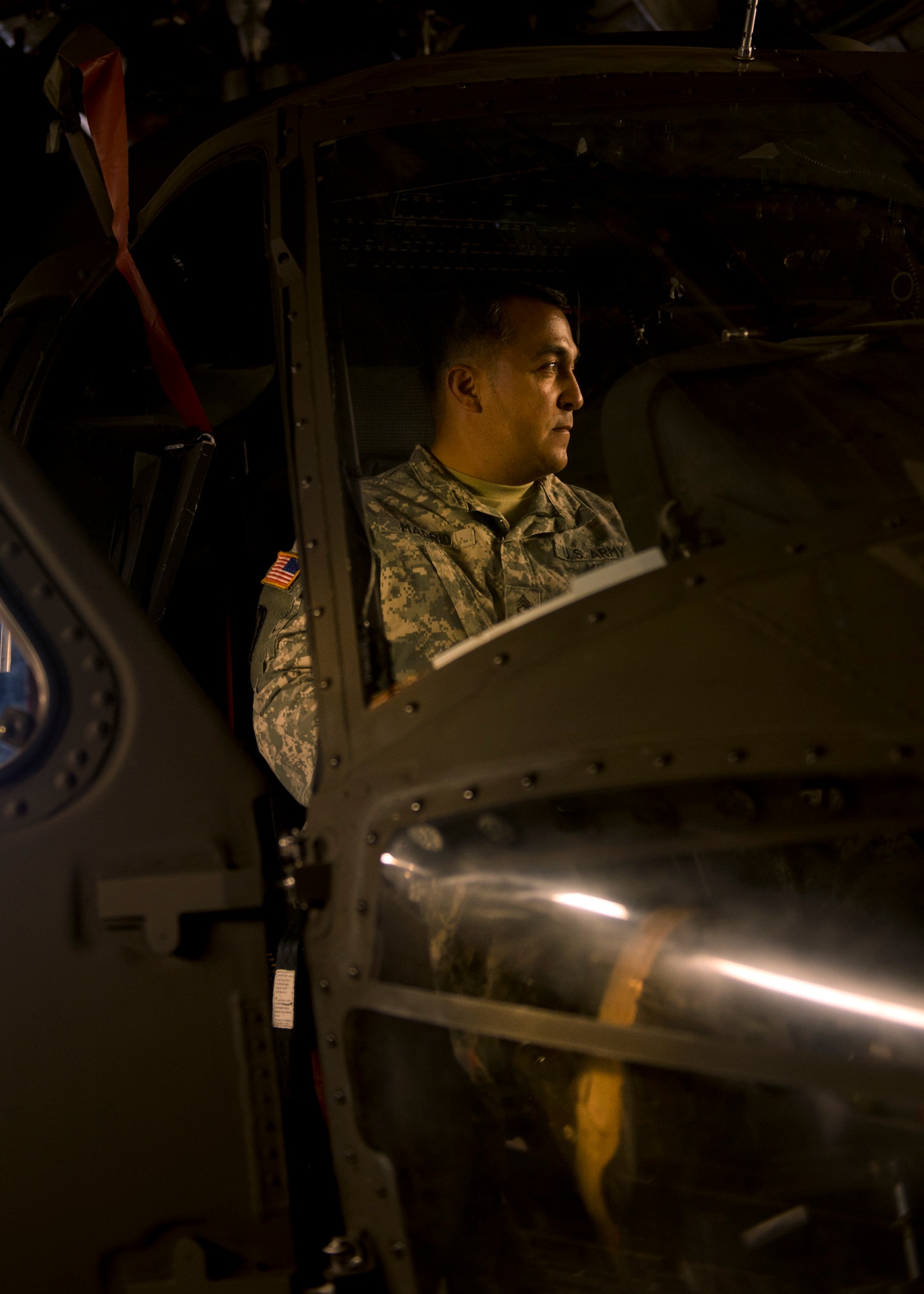 Army Sgt. 1st Class Jose Madrid, from the 25th Combat Aviation Brigade Schofield Barracks, holds the brakes on a UH-60 Black Hawk that was loaded into a C-17 Globemaster III, from the 535th Airlift Squadron, on Joint Base Pearl Harbor-Hickam, Hawaii, Jan. 21, 2016. Three UH-60 were loaded on to the C-17 as part of recurring training between the Air Force and Army. (U.S. Air Force photo by Tech. Sgt. Aaron Oelrich/Released)
