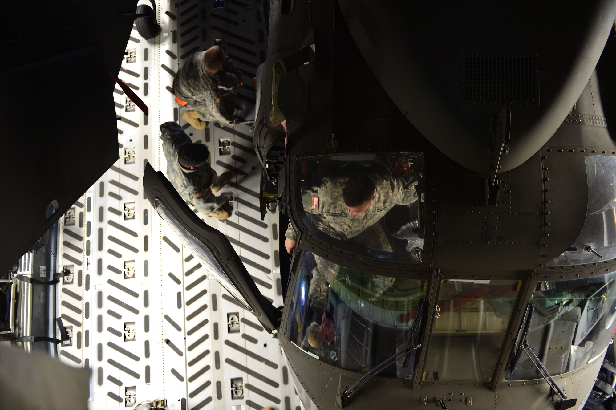 Soldiers, from 25th Combat Aviation Brigade Schofield Barracks, assist with the loading of a UH-60 Black Hawk, from the 25th CAB, into a C-17 Globemaster III, from the 535th Airlift Squadron, on Joint Base Pearl Harbor-Hickam, Hawaii, Jan. 21, 2016. Three UH-60 were loaded on to the C-17 as part of recurring training between the Air Force and Army. (U.S. Air Force photo by Tech. Sgt. Aaron Oelrich/Released)