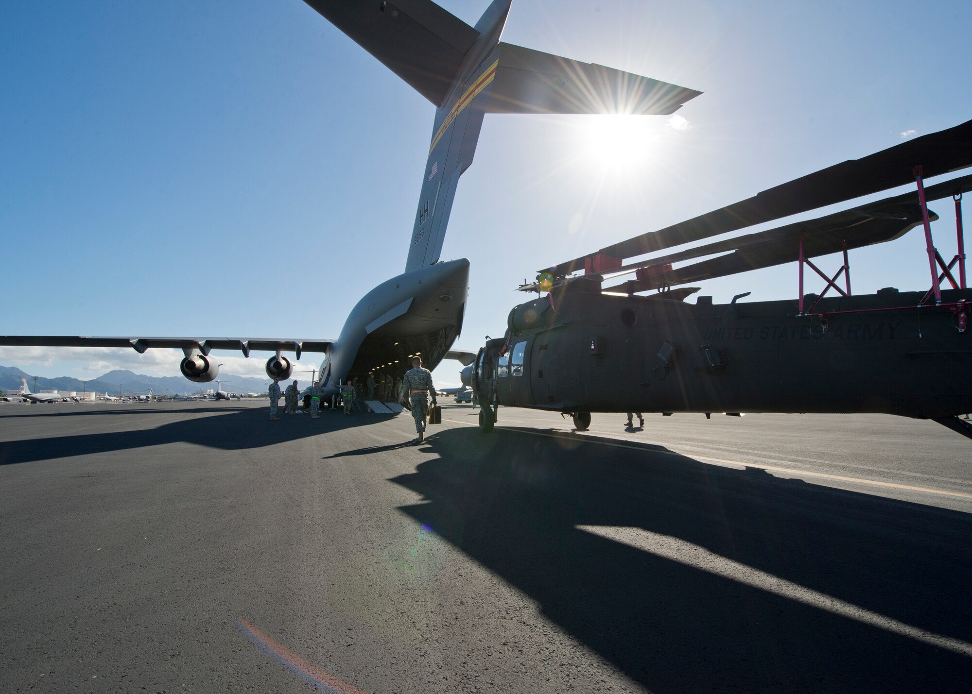Soldiers, from 25th Combat Aviation Brigade Schofield Barracks, and Airmen from the 535th Airlift Squadron worked together to load three UH-60 Black Hawk into a C-17 Globemaster III, from the 535th AS, on Joint Base Pearl Harbor-Hickam, Hawaii, Jan. 21, 2016. Three UH-60 were loaded on to the C-17 as part of recurring training between the Air Force and Army. (U.S. Air Force photo by Tech. Sgt. Aaron Oelrich/Released)