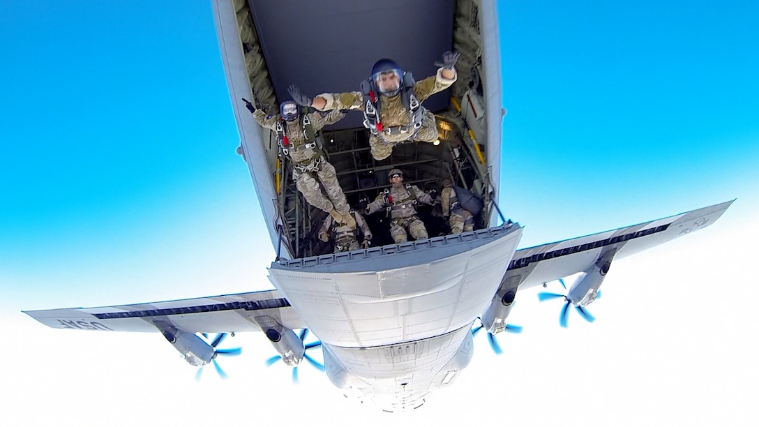 Airmen leap from the back of a C-130J Hercules during a parachute jump over Keesler Air Force Base in Biloxi, Miss., Jan. 20, 2016. The airmen are assigned to the 334th and 335th Training Squadrons. U.S. Air Force photo by Matt Hames