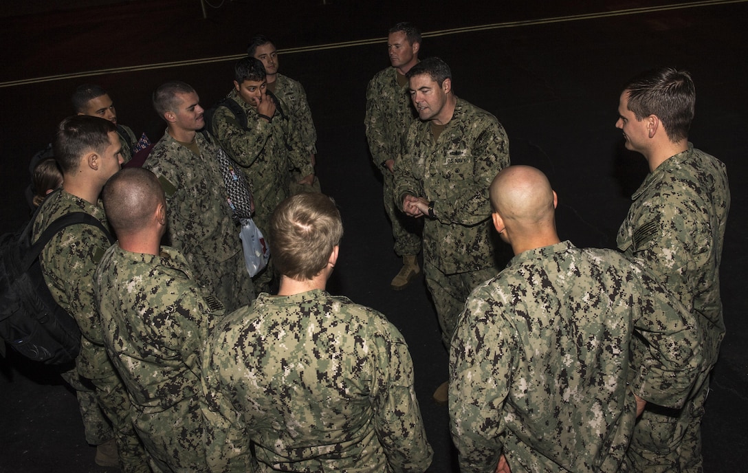 Capt. Gary Leigh, center right, commander, Coastal Riverine Group One, greets the 10 U.S. Navy sailors assigned to Coastal Riverine Squadron Three, upon their return to Naval Air Station North Island, to complete the final phase of reintegration and to be reunited with their families. The sailors were briefly detained by Iran Jan. 12-13 and are in good health. Image altered for security and privacy purposes. U.S. Navy photo by Mass Communication Specialist 1st Class Charles White/ Released