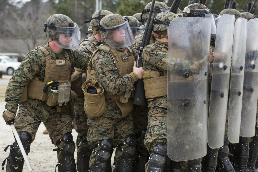 U.S. Marines with Battalion Landing Team, 1st Battalion, 6th Marine Regiment, 22nd Marine Expeditionary Unit (MEU), hold riot shields to prevent injury during a simulated riot at Camp Lejeune, N.C., Jan. 22, 2016. The Marines participated in the course to ensure mission readiness and to improve their ability to maintain control during a riot. (U.S. Marine Corps photo by Cpl. John A. Hamilton Jr./Released)