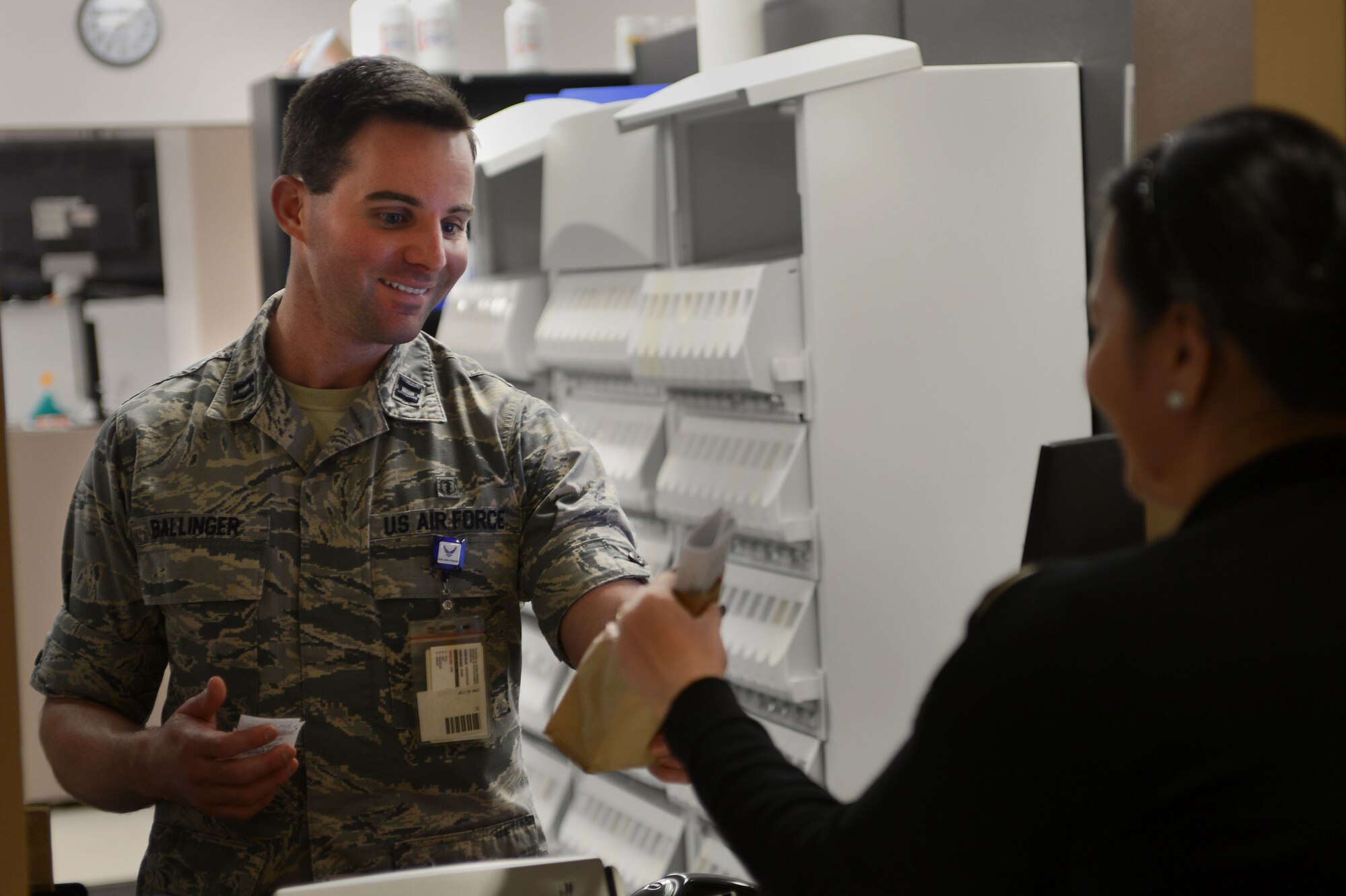U.S. Air Force Capt. Chase Ballinger, 20th Medical Support Squadron pharmacist, hands a prescription to a patient at Shaw Air Force Base, S.C., Jan. 21, 2016. The 20th MDSS pharmacy team’s purpose is to provide patients with safe and effective medications and assist the 20th Medical Group’s clinical staff with appropriate drug therapy. (U.S. Air Force photo by Senior Airman Zade Vadnais)