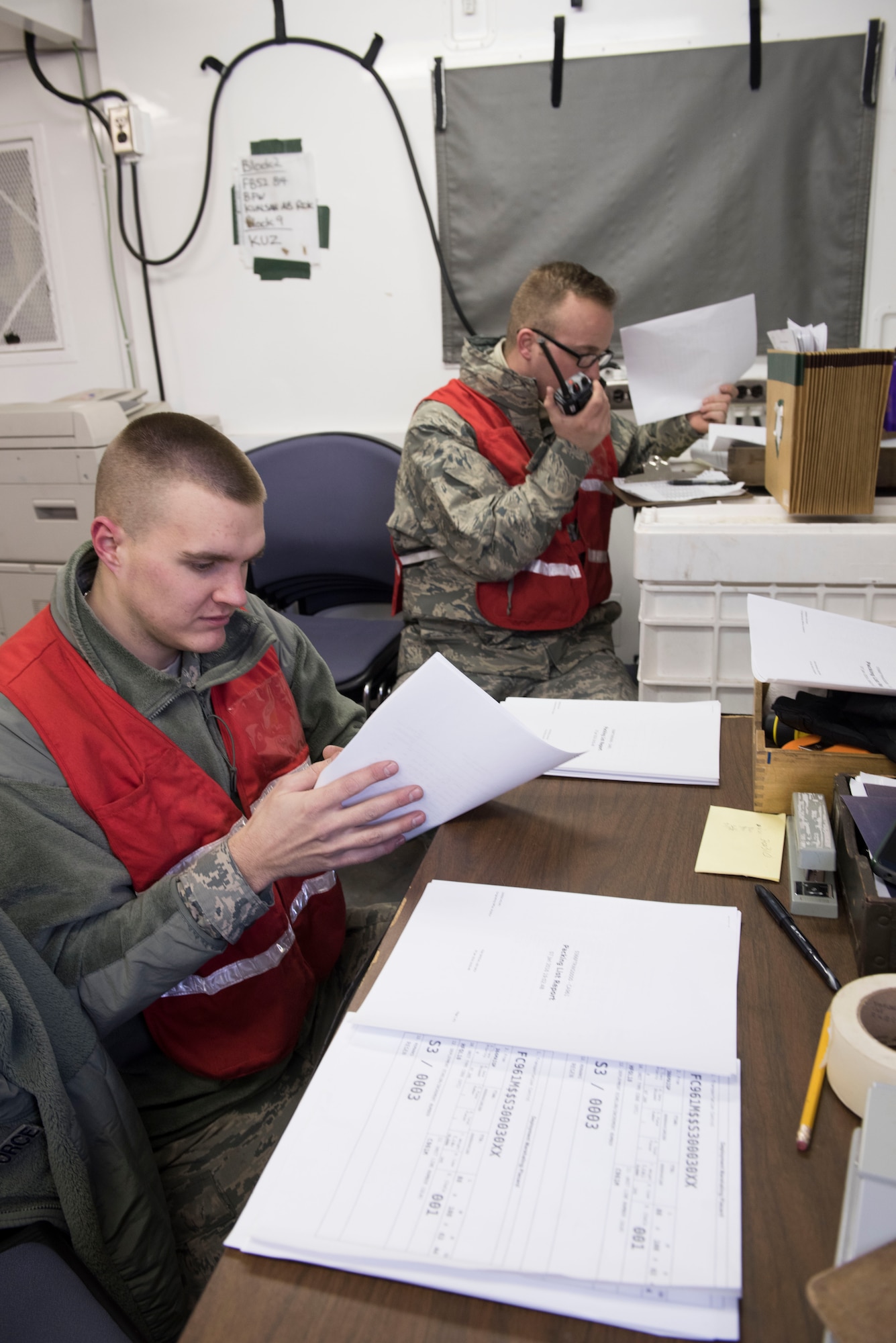 Tech. Sgt. Jordan Scheller and Airman 1st Class Trent Carper, both 366th Logistics Readiness Squadron float yard augmentees, process cargo paperwork, Jan. 22, 2016, at Mountain Home Air Force Base, Idaho. In-check personnel are responsible for verifying equipment has been received for processing and ensuring it is properly marked and packaged and meets safety and in-transit visibility requirements for transport. (U.S. Air Force photo by Senior Airman Lauren-Taylor Levin/RELEASED)