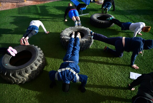 Airmen perform elevated pushups during the Warrior Trained Fitness event Jan. 25, 2016, at Creech Air Force Base, Nevada. The event was part of the Life of a Warrior campaign which aims to help keep Airmen combat-ready by enhancing their spiritual, mental, social, and physical resiliency. (U.S. Air Force photo by Senior Airman Christian Clausen/Released)