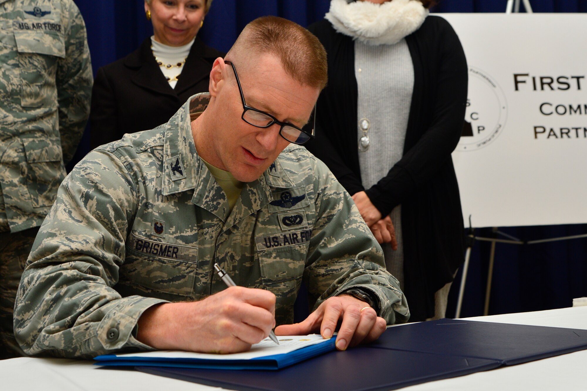 Col. Michael Grismer, 436th Airlift Wing commander, signs the Executive Charter during the First State Community Partnership Agreement signing event Jan. 20, 2016, at the Landings on Dover Air Force Base, Del. A total of nine Memorandums of Understanding were signed at the event. (U.S. Air Force photo/Senior Airman William Johnson)