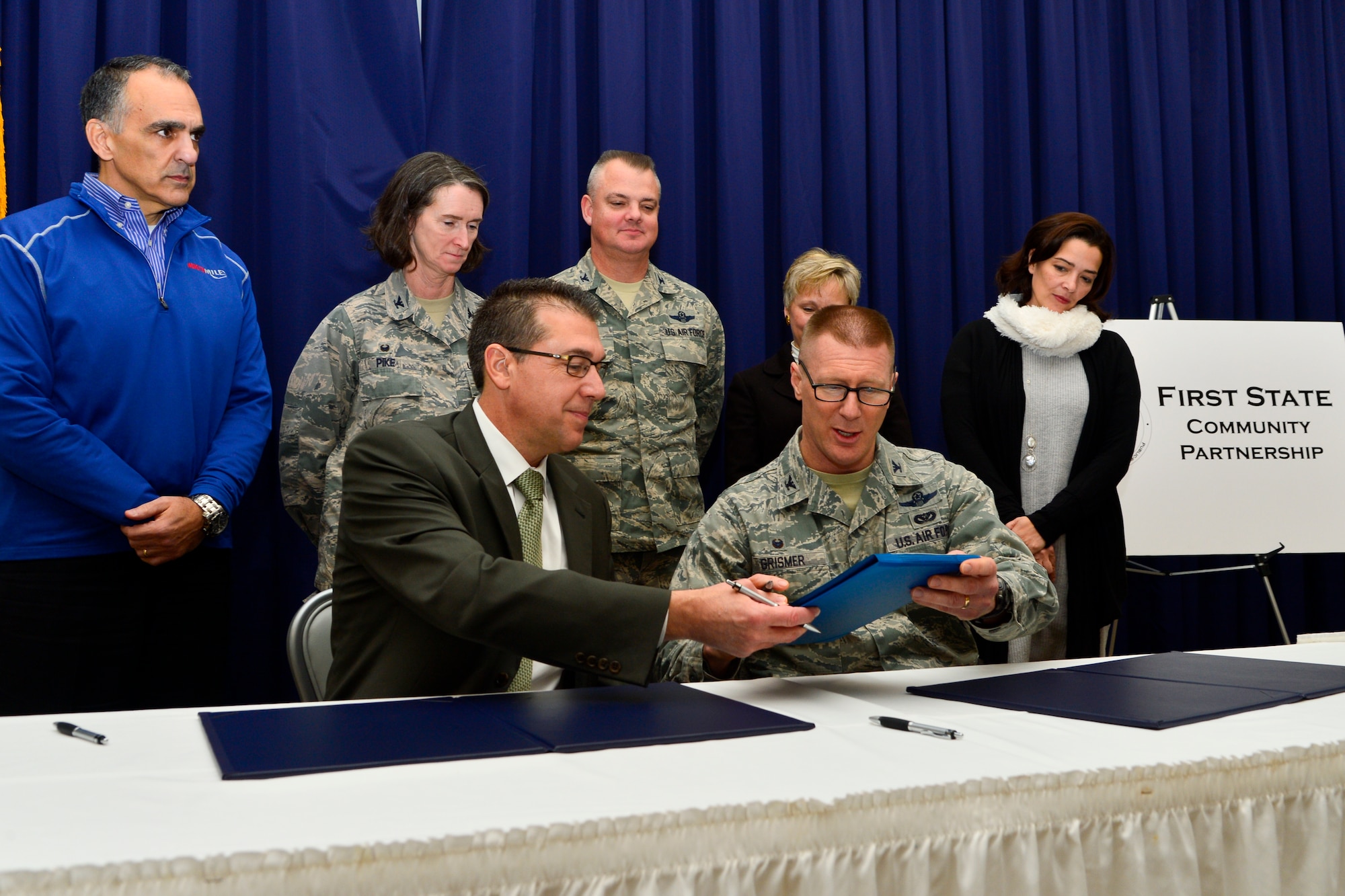 Brad Eaby, Kent County commissioner, Col. Michael Grismer, 436th Airlift Wing commander, and other members of the executive council sign the Executive Charter during the First State Community Partnership Agreement signing event Jan. 20, 2016, at the Landings on Dover Air Force Base, Del. The Executive Charter is an overarching document that cements the partnership between Dover AFB, community stakeholders and local government. (U.S. Air Force photo/Senior Airman William Johnson)