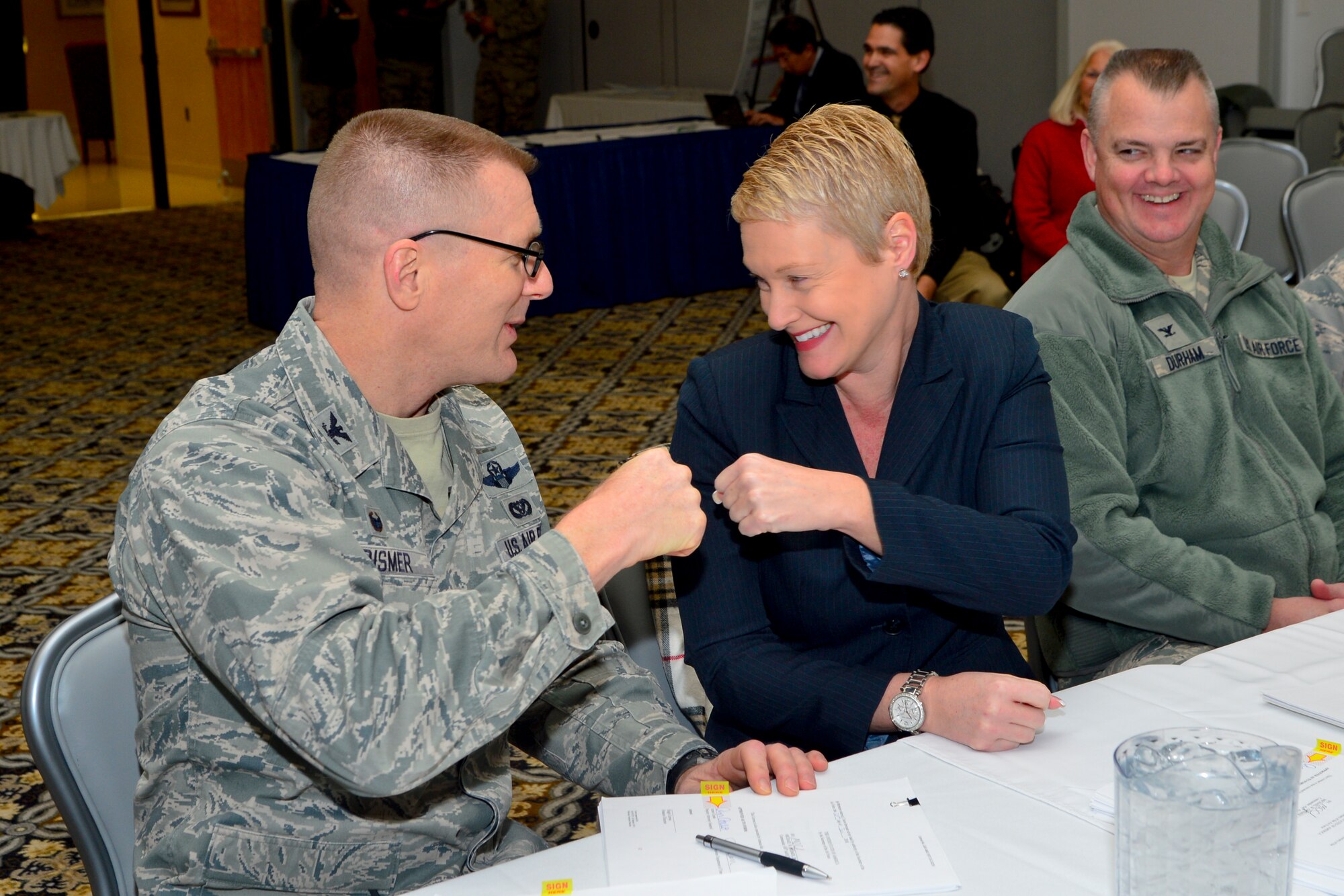 Col. Michael Grismer, 436th Airlift Wing commander, fist bumps Jennifer Cohan, Delaware Depart of Transportation secretary, after signing the licensing agreement for the Civil Air Terminal during the First State Community Partnership Agreement signing event Jan. 20, 2016, at the Landings on Dover Air Force Base, Del. The agreement allows for expanded use of the Civil Air Terminal on Dover AFB by non-military aircraft. (U.S. Air Force photo/Senior Airman William Johnson)