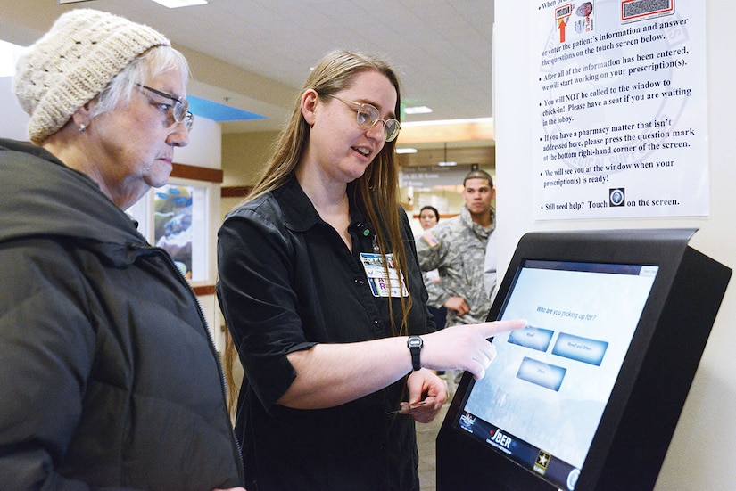 Trixy Buttcane, 673d Medical Support Squadron contract certified pharmacy technician, assists a patient navigating the new pharmacy kiosk system at the hospital on Joint Base Elmendorf-Richardson, Alaska, Jan. 19, 2015. For the first three months, technical assistants helped patients learn the new system to effectively transition the populace to the change. (U.S. Air Force photo by Airman 1st Class Christopher R. Morales)
