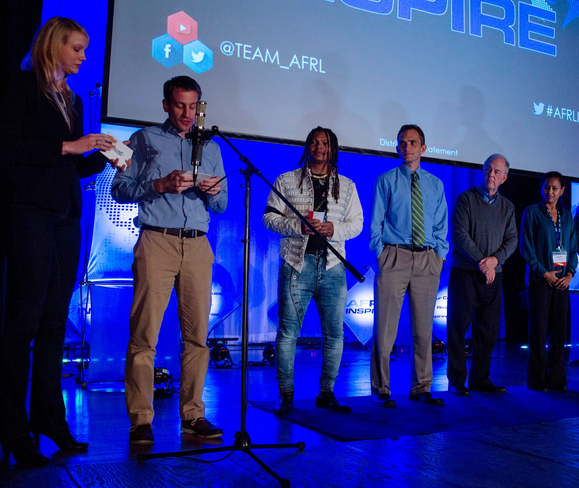 Kerianne Gross and Dr. Dan Berrigan (left), architects of AFRL Inspire, served as the event’s emcees.  Also pictured are four presenters from the inaugural AFRL Inspire event. From left: Dr. Moriba Jah, Dr. Jeff Calcaterra, Dr. Robert Fugate, and Dr. Nandini Iyer. (U.S. Air Force photo / Mikee Huber)