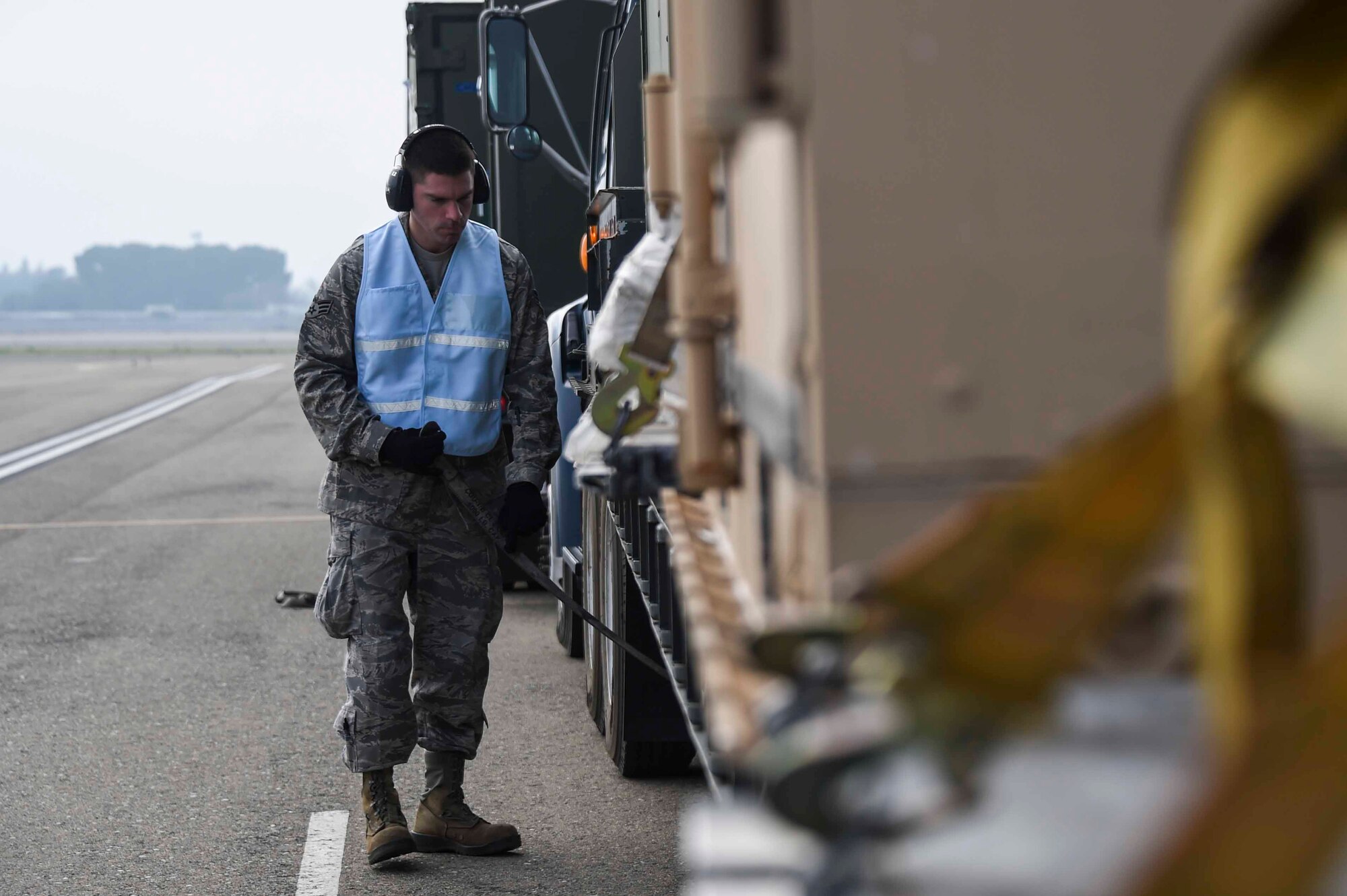 U.S. Air Force Senior Airman Eric Cruz, 144th Fighter Wing vehicle operator, helps unlatch cargo at the Fresno Air National Guard Base, Jan. 21, 2016, in preparation of Red Flag 16-01. Red Flag is a realistic combat training exercise, which is hosted by Nellis Air Force Base, Nevada and the U.S. Air Force Warfare Center. (U.S. Air National Guard Senior Airman Klynne Pearl Serrano)