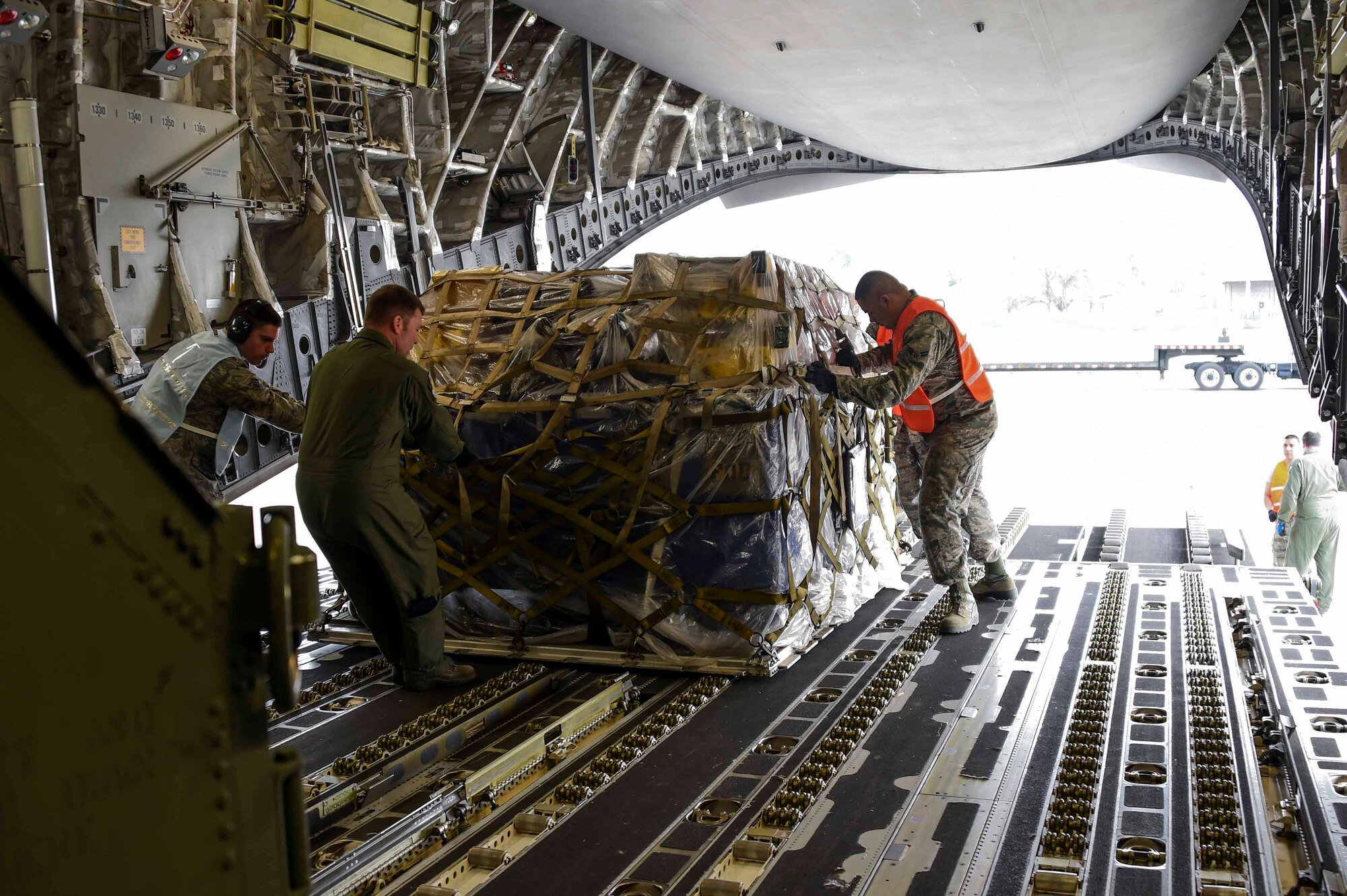 Airmen assigned to the New York Air National Guard’s 105th Airlift Wing and Fresno ANG’s 144th Fighter Wing, slide a pallet aboard a C-17 Globemaster III at the Fresno ANG Base, Jan. 21, 2016, in support of the 144th FW's participation in Red Flag 16-01. Red Flag is a realistic combat training exercise, which is hosted by Nellis Air Force Base, Nevada and the U.S. Air Force Warfare Center. The 105th AW airlifted 12 pallets and 29 personnel assigned to the 144th FW. (U.S. Air National Guard Senior Airman Klynne Pearl Serrano)