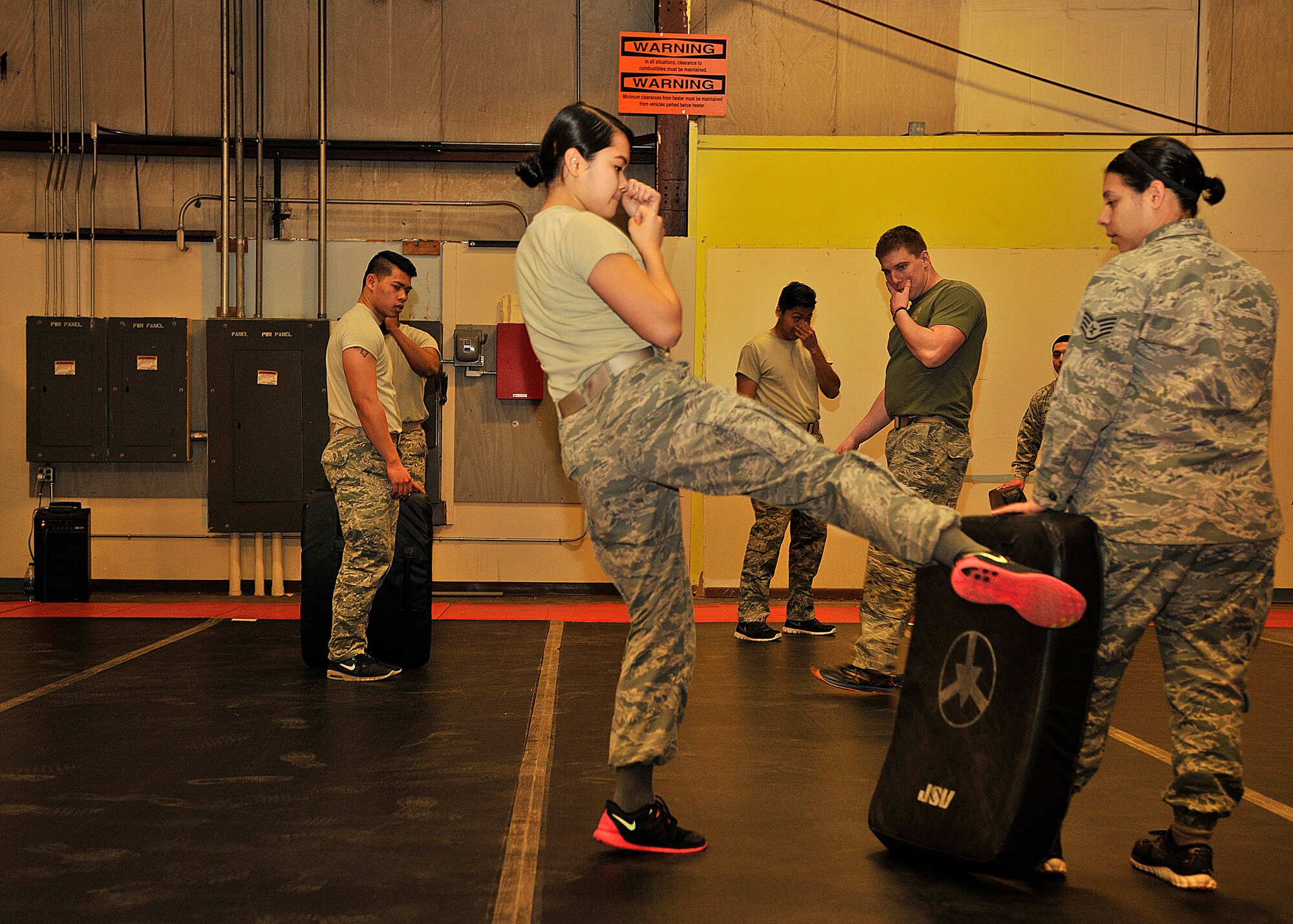 Members of the 319th Logistics Readiness Squadron demonstrate their kicking techniques during combative training on Jan. 15, 2016 on Grand Forks Air Force Base, North Dakota. The overall goal of combative training is to focus on skills that all warriors should have at a foundational level. (U.S. Air Force photo by Senior Airman Xavier Navarro/Released)
