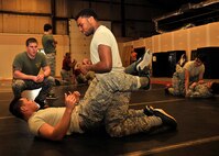 Members of the 319th Logistics Readiness Squadron go through steps of a ground evasive technique during combative training on Jan. 15, 2016 on Grand Forks Air Force Base, North Dakota. The objective of training is to teach unarmed combat skills and is offered once a month. (U.S. Air Force photo by Senior Airman Xavier Navarro/Released)
