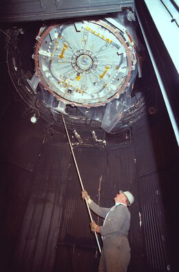 An AEDC rigger helps lower an International Space Station component, called a common berthing mechanism, into the 12V Aerospace Thermal Vacuum chamber at the Complex for simulated space environment testing in 1995. (U.S. Air Force photo/Gary Barton)