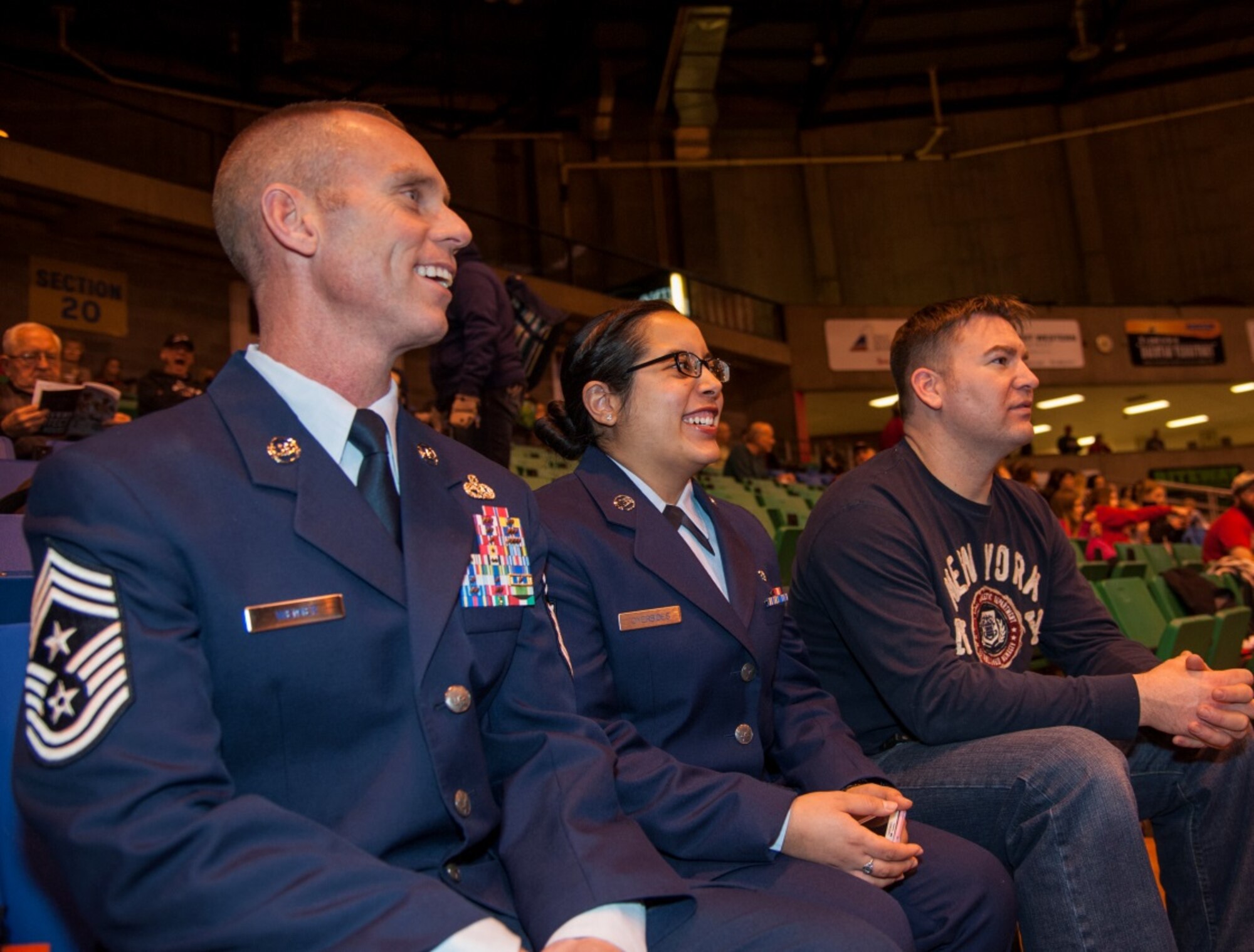 Chief Master Sgt. Geoff Weimer, 5th Bomb Wing command chief, sits with Senior Airman Rebekah Oyerbides, who performed the National Anthem at the Minot State University men’s basketball game Jan.  15, 2016. Weimer and Oyerbides watched as the Beavers beat the opposing team after he threw the honorary tip off for military appreciation day. (U.S. Air Force photo/Airman 1st Class Christian Sullivan)