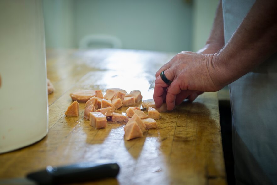 A volunteer cuts meat during the Sportsmen Feed meat cut-up event at Bloms’ Locker & Processing in Minot, N.D., Jan. 22, 2015. The cut-up event preceeds the Sportsmen Feed event on base, which features an array of wild game. (U.S. Air Force photo/Senior Airman Apryl Hall)