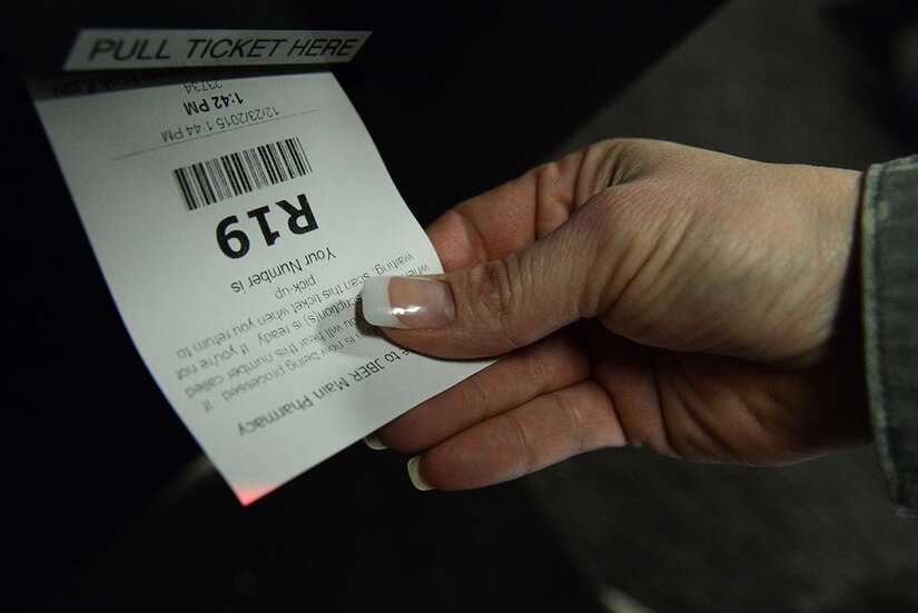 A patient pulls her ticket from the new pharmacy kiosk at the hospital on Joint Base Elmendorf-Richardson, Alaska, Dec. 23, 2015. Patients have the option to wait at the pharmacy to pick up their prescription or leave and re-enter the queue within seven days. (U.S. Air Force photo by Airman 1st Class Christopher R. Morales)