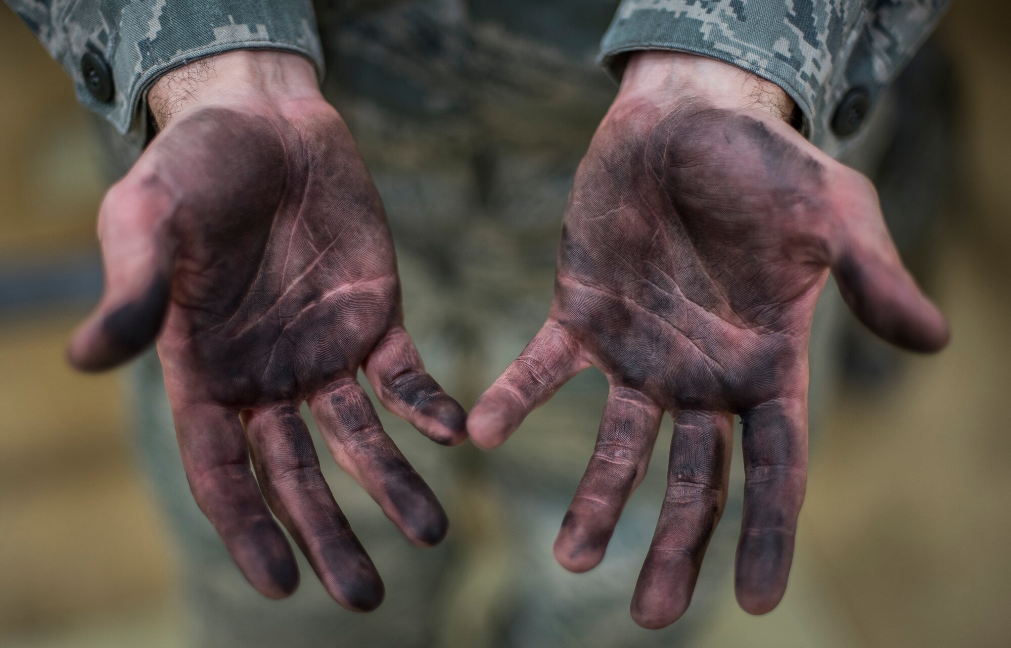 Senior Airman Tyler Susskind, an aerospace propulsion journeyman with the 35th Aircraft Maintenance Squadron, displays the grease on his hands at Misawa Air Base, Japan, Jan. 25, 2015. After a long day’s work, Susskind’s hands have an excess build-up of grease due to working on multiple components of an F-16 Fighting Falcon’s engine. (U.S. Air Force photo by Senior Airman Brittany A. Chase)