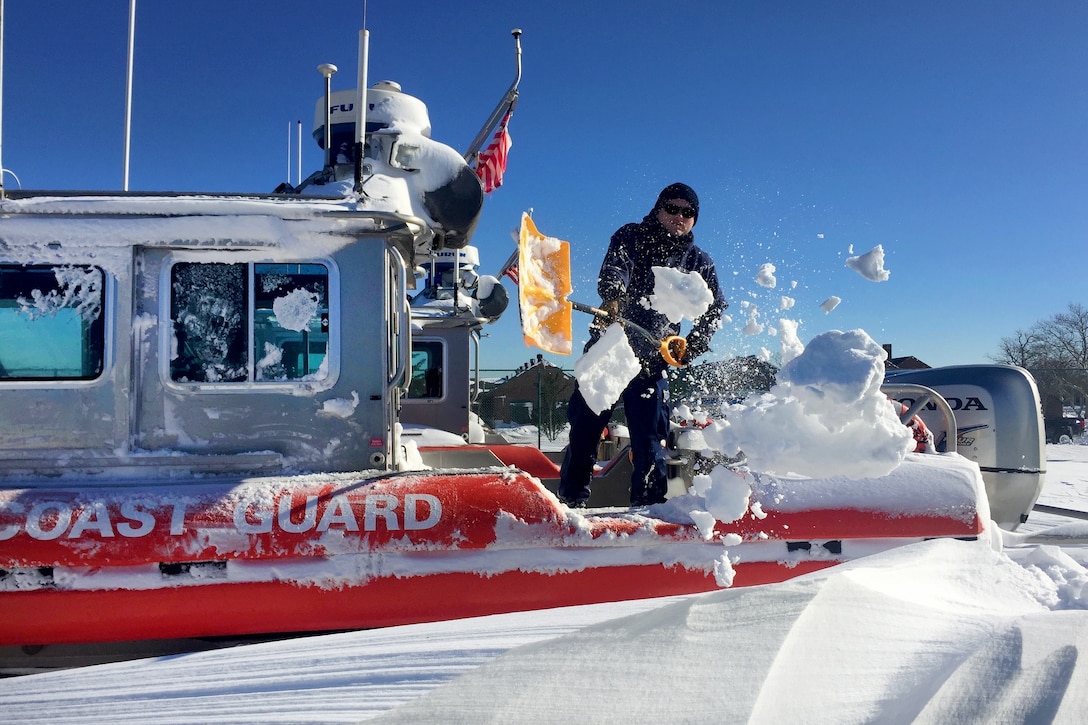 Coast Guard Petty Officer 2nd Class Richard Clarke III shovels snow off the deck of a 25-foot Coast Guard boat on  Coast Guard Station Sandy Hook, N.J., Jan. 24, 2016. A massive snowstorm hit the mid-Atlantic and East Coast Jan. 22-23, leaving more than two feet in most areas. U.S. Coast Guard photo by Petty Officer 1st Class Ty Coulter