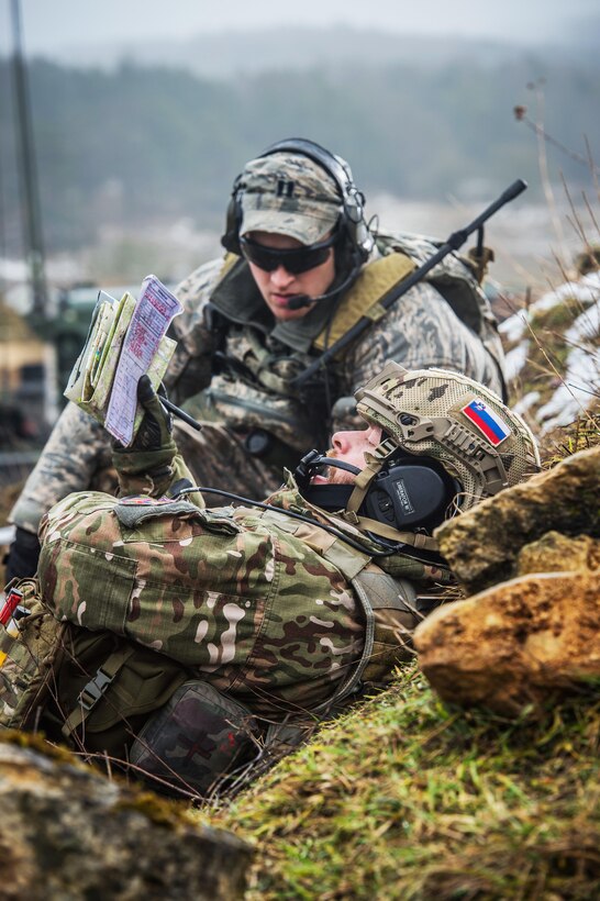 Slovenian Army Cpl. Anje Komac calls in fire support while U.S. Air Force Capt. Skylar Jackson, a Joint Terminal Attack Controller with the Bullseye Observer Coach Trainer Team acts as a training facilitator during exercise Allied Spirit IV at Hohenfels training area, Germany, Jan. 25, 2016. U.S. Army photo by Sgt. 1st Class Caleb Barrieau