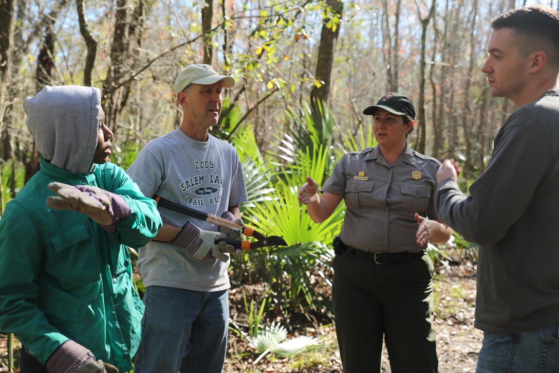 Supervisory Park Ranger Aleutia Scott delivers project instructions to volunteers from Marine Forces Reserve’s Chaplain’s Office at Barataria Nature Preserve, part of Jean Lafitte Historical Park and Preserve in Barataria, La., Jan. 16, 2016. MARFORRES religious program specialists routinely complete community enrichment projects to give back to the local community. 