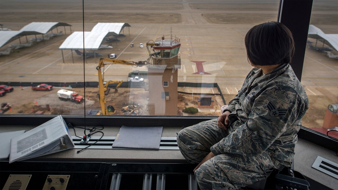Senior Airman Susana Twilley, a 71st Operations Support Squadron air traffic controller, watches the old control tower demolition from the cab of the new tower at Vance Air Force Base, Oklahoma, Jan. 21. The new tower stands almost four stories taller than its predecessor and houses state-of-the-art systems to help control Vance's busy skies more efficiently. Vance's tower was replaced after more than 40 years of service to the base's pilot training mission. (U.S. Air Force photo / David Poe)
