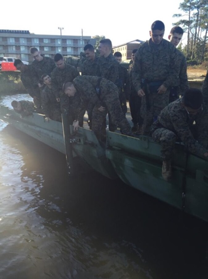 During a practical application on Improved Ribbon Bridges (IRBs), Marines attached to Basic Combat Engineer course 6-16 (BCE 6-16) connect a rafting bracket to a 'ramp bay' to help secure sections of the IRB at Marine Corps Engineer School, Camp Lejeune, N.C.

