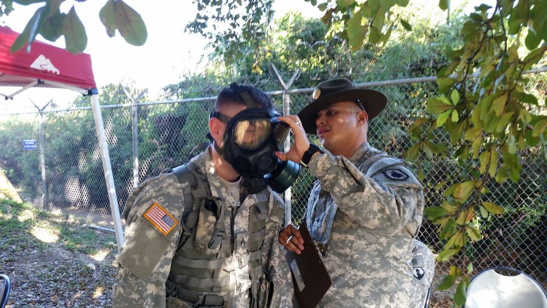 Drill Sergeant Edwin Toro evaluates a competitor on the proper wear and sealing of the M40 MASK during the second day of the 77th CSSB Best Warrior Competition held 22-24 January at Ramey Base, Aguadilla, Puerto Rico.