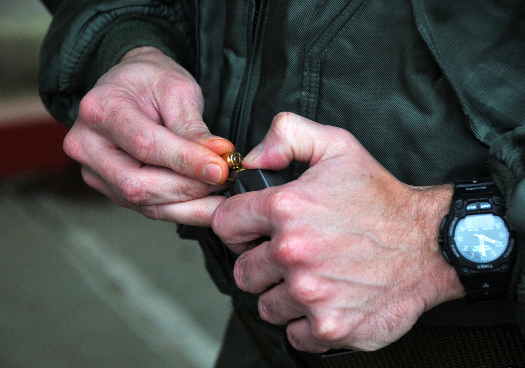 A qualifier loads 9mm bullets into a magazine at the shooting range Jan. 9, 2015 at Dobbins Air Reserve Base, Ga. Qualifiers use three 15-round magazines for practice shots and then another three 15-round magazines for the qualification. (U.S. Air Force photo/ Senior Airman Andrew J. Park)