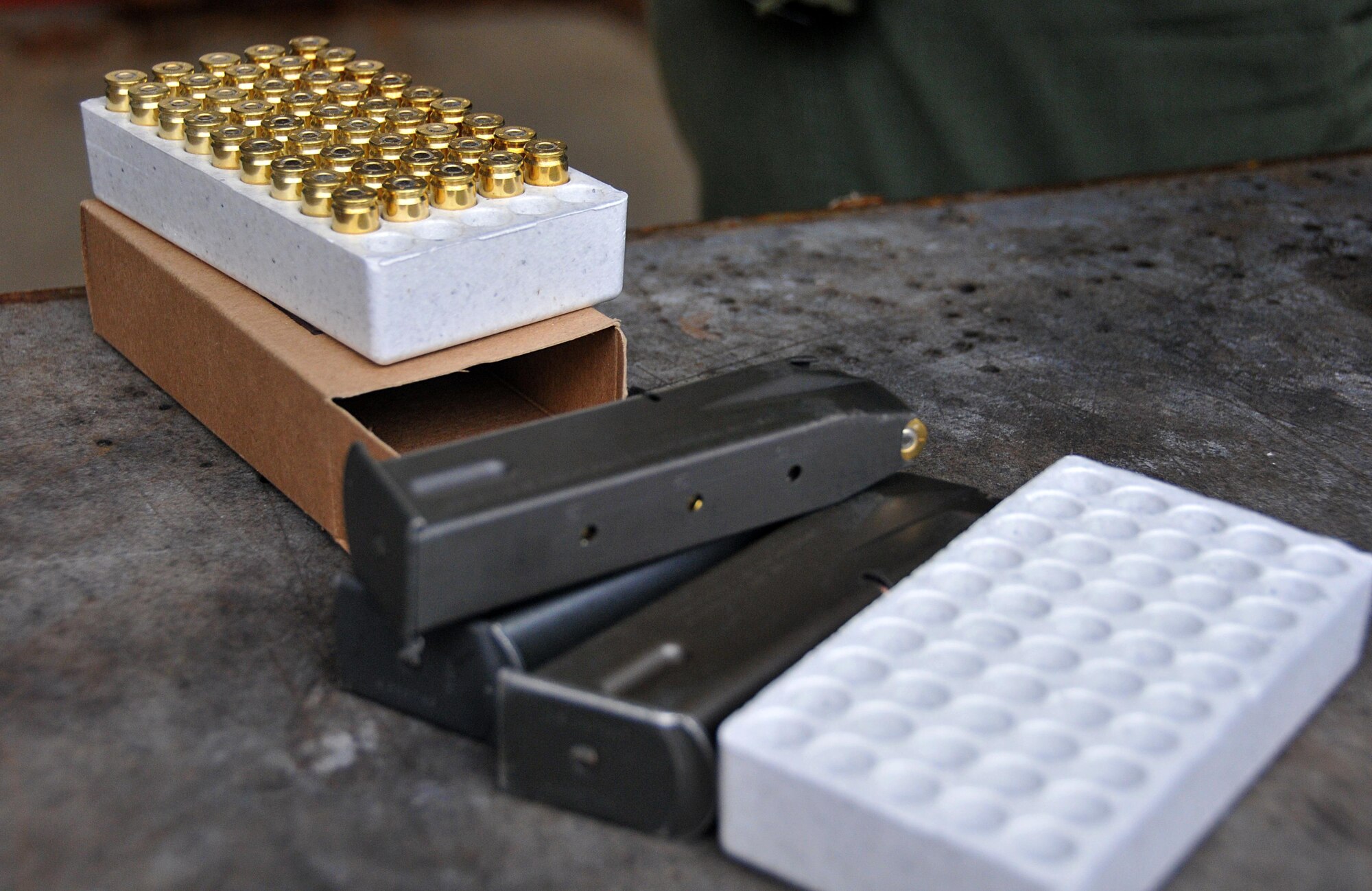 Three 15-round 9mm magazines and a case of bullets sit on a table at the Dobbins shooting range Jan. 9, 2015 at Dobbins Air Reserve Base, Ga. Qualifiers were provided with a total of 90 rounds of ammunition to complete the qualification course. (U.S. Air Force photo/ Senior Airman Andrew J. Park)