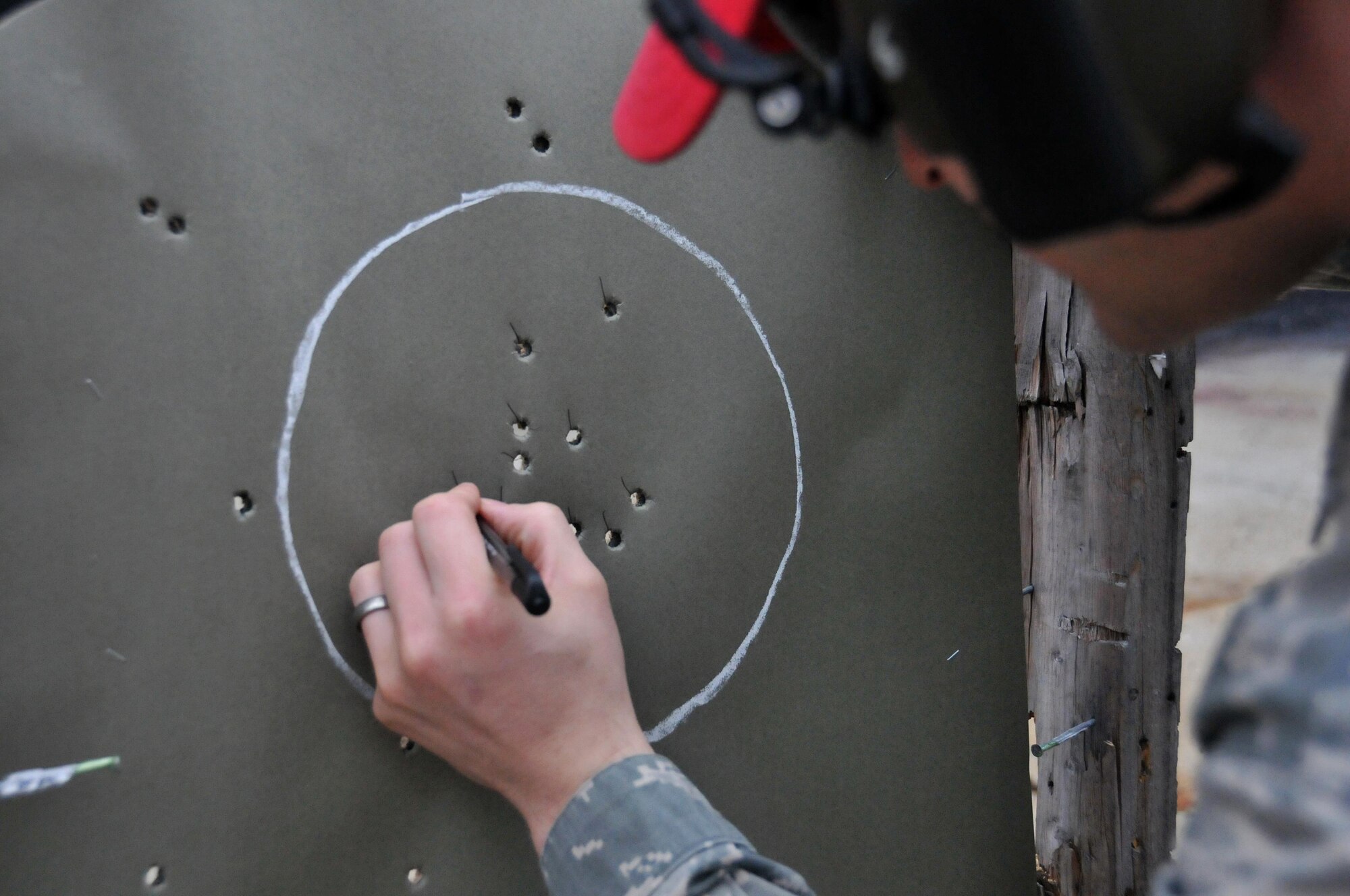 Staff Sgt. Warren Powell, 94th Airlift Wing combat arms instructor, scores the center-mass portion of a target during a small arms qualification process Jan. 9, 2015 at Dobbins Air Reserve Base, Ga. To qualify as an expert shooter, students must have six shots to the head area of the target and 25 shots to the center-mass area of the target. (U.S. Air Force photo/ Senior Airman Andrew J. Park)