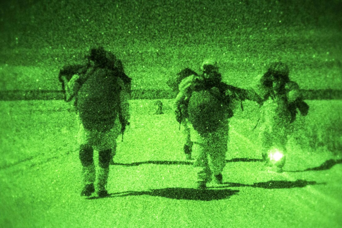 As seen through a night-vision device, paratroopers proceed to the rally point after participating in a night jump onto Malemute drop zone on Joint Base Elmendorf-Richardson, Alaska, Jan. 21, 2016. U.S. Air Force photo by Alejandro Pena