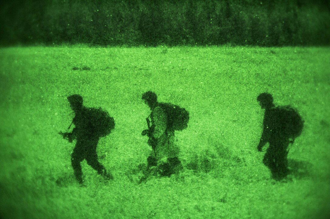 As seen through a night-vision device, U.S. and Canadian paratroopers proceed to the rally point after participating in a night jump onto Malemute drop zone on Joint Base Elmendorf-Richardson, Alaska, Jan. 21, 2016. U.S. Air Force photo by Alejandro Pena