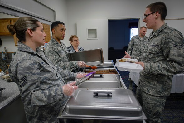 From left, Tech. Sgt. Jennifer DiBello and Lt. Col. Erick Castro serve single Airmen during a SIGMO at Vance Air Force Base, Oklahoma, Jan. 25. Singles' International Gourmet Meal Opportunities are Chaplain-funded meals hosted by a different squadron or group each month. They’re primarily for single and unaccompanied Airmen, as well as for the families of deployed Airmen. DiBello and Castro are the 71st Force Support Squadron military personnel section NCOIC and squadron commander respectively. (U.S. Air Force photo /David Poe)