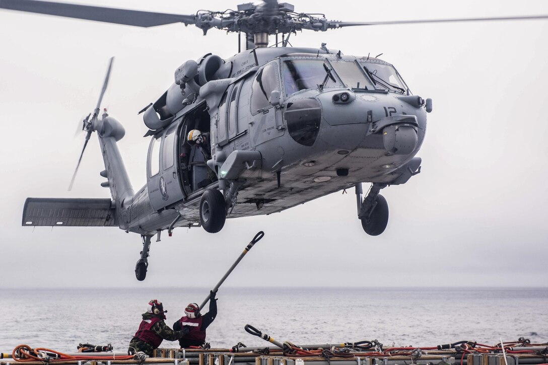 Navy Petty Officer 1st Class Charles Robinson and Seaman Vernon Henderson hook ordnance to an MH-60S Seahawk to ship from the USS John C. Stennis to the USNS Rainier during an replenishment in the Pacific Ocean, Jan. 18, 2016. Robinson is an aviation ordnanceman and Henderson is an aviation ordnanceman airman. The Seahawk is assigned to Helicopter Sea Combat Squadron 14. U.S. Navy photo by Petty Officer 3rd Class Kenneth Rodriguez Santiago