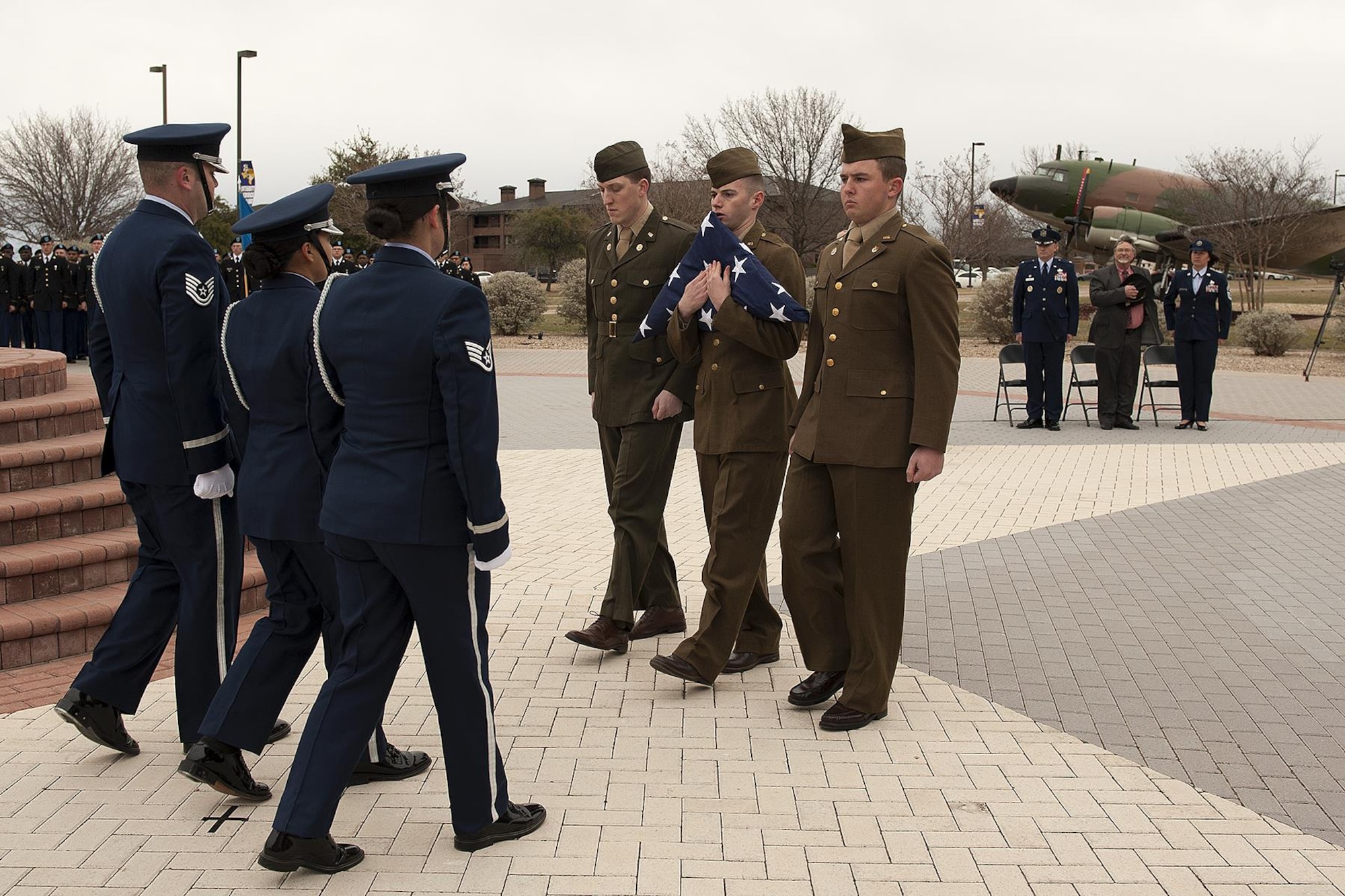 Goodfellow Air Force Base Honor Guard members dressed in 1940 uniforms hand off the U.S. flag during the 75th Diamond Anniversary flag raising reenactment at the Norma Brown building on Goodfellow Air Force Base, Texas, Jan. 26, 2016. The base honor guard and various volunteers wore Army Air corps uniforms as part of the reenactment ceremony. (U.S. Air Force photo by Airman 1st Class Caelynn Ferguson/Released)