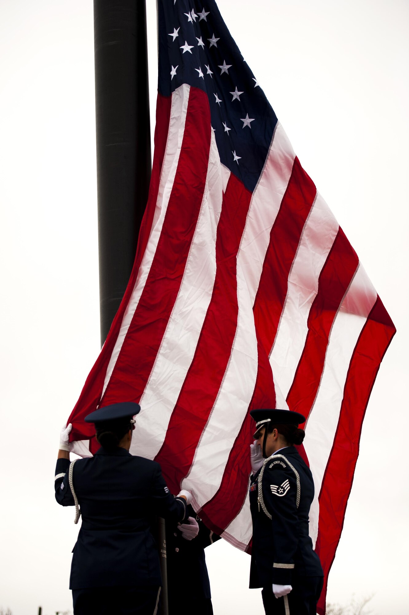 Goodfellow Air Force Base Honor Guard raises a flag during the 75th Diamond Anniversary ceremony at the Norma Brown building on Goodfellow Air Force Base, Texas, Jan. 26, 2016. Honor guard members dressed in uniforms from the 1940s passed off the flag to a contemporary fitted honor guard to honor all generations of Goodfellow. (U.S. Air Force photo by Senior Airman Scott Jackson/Released)