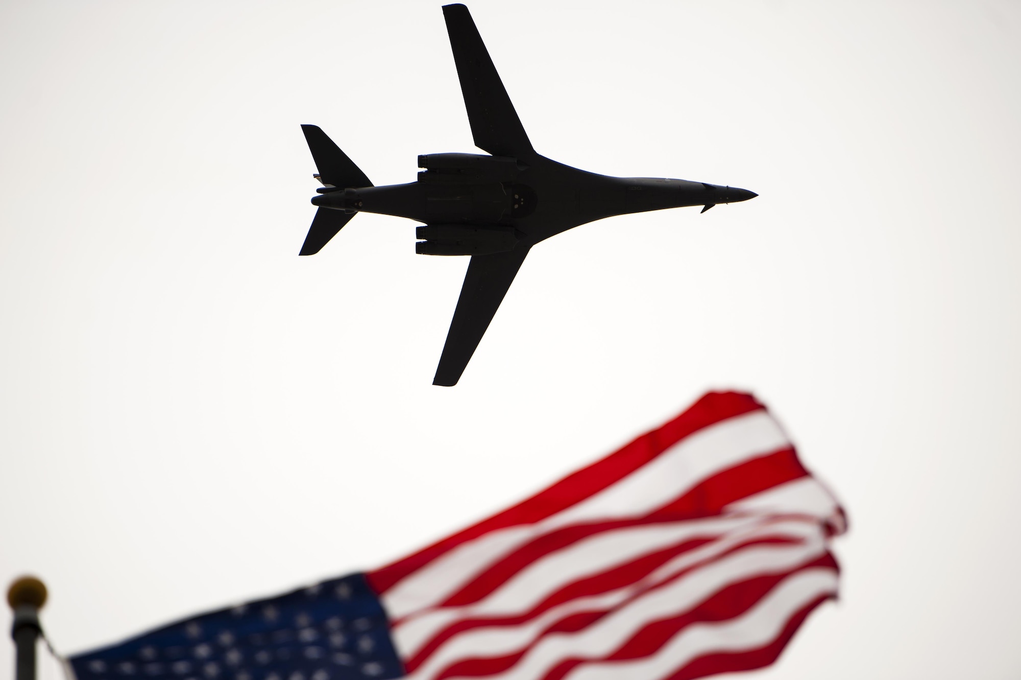 A Rockwell B-1 Lancer flies over the Norma Brown building during the 75th Diamond Anniversary ceremony on Goodfellow Air Force Base, Texas, Jan. 26, 2016. The B-1 flew over after a Vultee BT-15 Valient flew over. Both were symbolic; the vintage BT-15 representing the planes that Goodfellow pilots trained on, and the B-1 representing the intelligence support training the base now provides. (U.S. Air Force photo by Senior Airman Scott Jackson/Released)