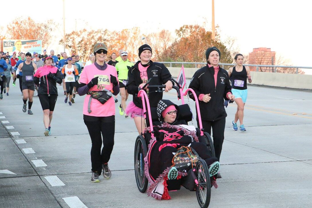 Captain Danielle Falcon, Marine Corps Recruiting Station Baton Rouge executive officer, pushes a member of Ainsley’s Angels of America during the Louisiana Half-Marathon on Jan. 17, 2016. Ainsley's Angels of America aims to build awareness about America's special needs community through inclusion in all aspects of life. The organization was started by Major Kim Rossiter who is currently stationed in Norfolk, Va. Major Rossiter's daughter, Ainsley, is a child with Infantile Neuroaxonal Dystrophy which is a rare terminal illness that progressively causes global paralysis. (U.S. Marine Corps photo by Sgt. Rubin J. Tan/Released)