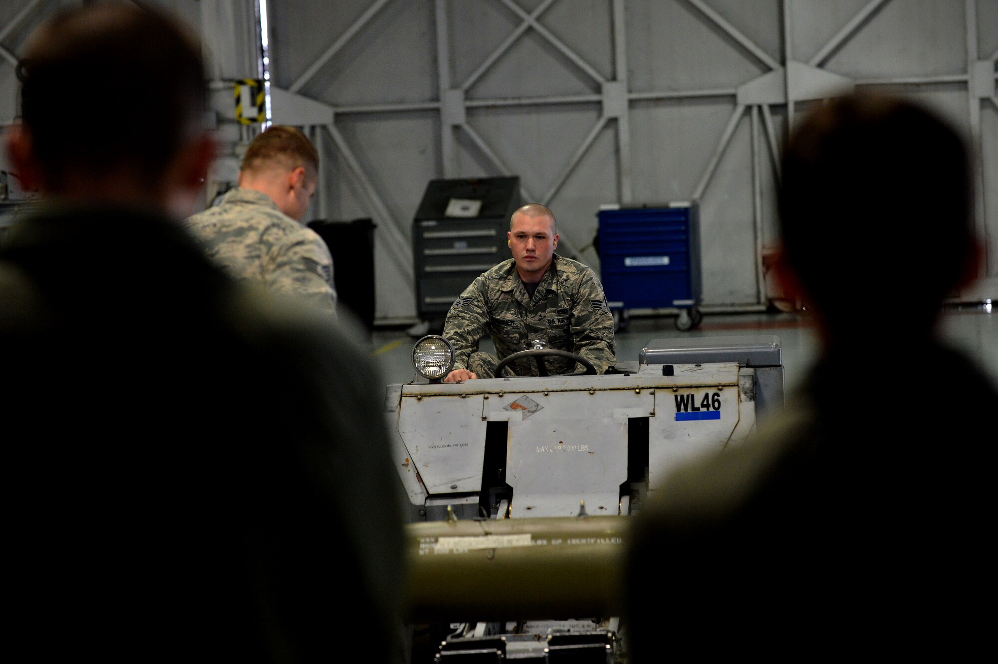 U.S. Air Force Senior Airman Timothy Boehmer, 20th Equipment Maintenance Squadron load crew member, lifts a munitions using a weapons loader during a Load Crew of the Year competition at Shaw Air Force Base, S.C., Jan. 22, 2016. During a load crew competition teams compete to see who can load munitions the fastest and the safest. (U.S. Air Force photo by Senior Airman Michael Cossaboom)