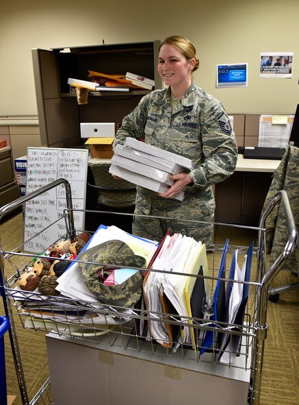 Master Sgt. Beci Hilgeman, chief of education and training, is all smiles as she moves her office and the education testing area, Jan. 15, 2016, Scott Air Force Base, Illinois.  The move is part of several changes happening in the 932nd Airlift Wing headquarters building.  Many of the Force Support Squadron offices either moved or rearranged furniture to better serve the wing and customers. It has been a long time coming, said Hilgeman about the improved testing room.  She said it will finally be equal to the level of respect needed for testing and the importance of promotion, upgrades and even discharges for the wing. (U.S. Air Force photo by Christopher Parr)