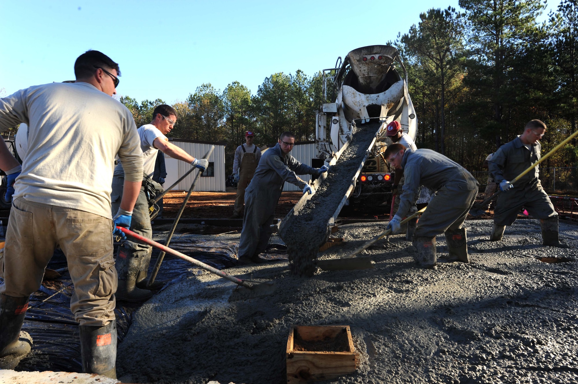 Airmen from the 823rd Rapid Engineer Deployable Heavy Operational Repair Squadron Engineer (RED HORSE) from Hurlburt Field, Florida, smooth concrete for what will be a new latrine facility at the Vigilant Warrior training site Dec. 15, 2015, near Titus, Alabama. RED HORSE is scheduled to have all new construction projects finished no later than April 2016. (U.S. Air Force photo by Airman 1st Class Alexa Culbert)