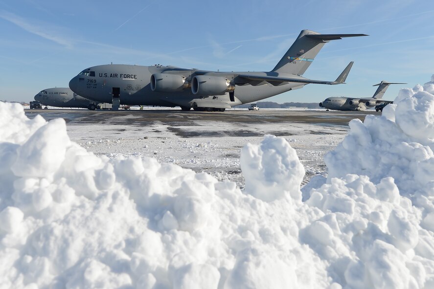 ??????C-17A Globemaster III aircraft are framed by a snowbank following Winter Storm Jonas Jan. 25, 2016, at Dover Air Force Base, Del. The two aircraft in the foreground are from the 436th Airlift Wing, Dover AFB, while the third is based at Joint Base McGuire-Dix-Lakehurst, N.J., as part of the 305th Air Mobility Wing. Despite the 22 inches of snow dumped on the base, the runway and flight lines were cleared to allow the base to resume normal flight operations within hours of the duty day beginning. (U.S. Air Force photo/Greg L. Davis)