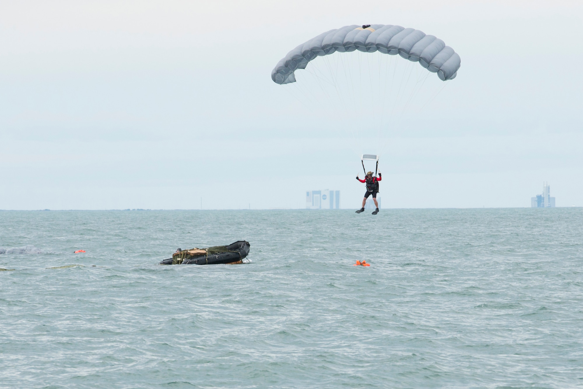 An Air Force Reserve pararescueman descends into the Atlantic Ocean from an Air Force C-17 Globemaster III in an effort to recover a NASA astronaut as part of an exercise Jan. 14 off the shore of Cape Canaveral Air Force Station, Florida. The 45th Operations Group Detachment 3 joined NASA's Commercial Crew Program and Air Force pararescuemen, combat rescue officers and survival, evasion, resistance and escape specialists to simulate to practice recovering astronauts quickly and safely in the event they would need to abort their spacecraft. The small Air Force detachment has served as the liaison between NASA’s Johnson Space Center in Houston, Texas, the Air Force and Department of Defense for more than 55 years, training men and women of those organizations for launch contingencies and astronaut recovery. (U.S Air Force photo/Matthew Jurgens) (Released)